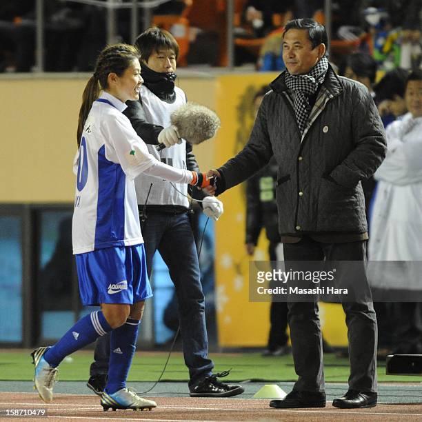 Norio Sasaki and Homare Sawa shake hands during the Great East Japan Earthquake charity match 'SAWA and Friends, X'mas Night 2012' at the National...
