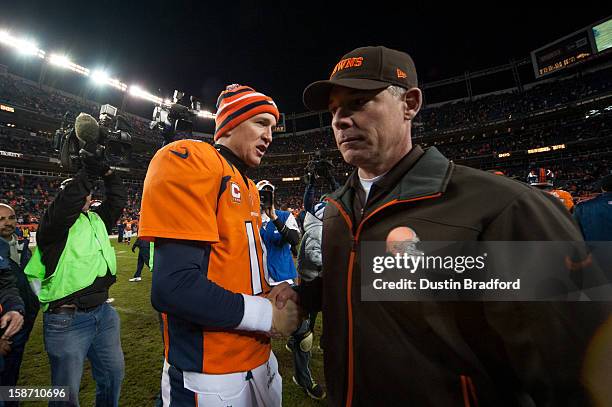 Quarterback Peyton Manning of the Denver Broncos shakes hands with head coach Pat Shurmur of the Cleveland Browns after a game at Sports Authority...