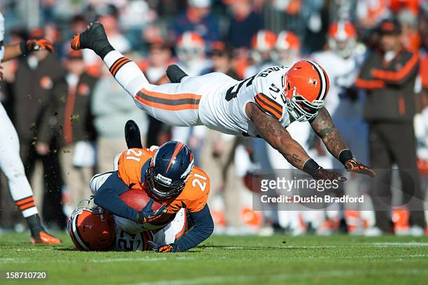 Defensive end Juqua Parker of the Cleveland Browns flies through the air as he and teammate free safety Eric Hagg combine to tackle running back...