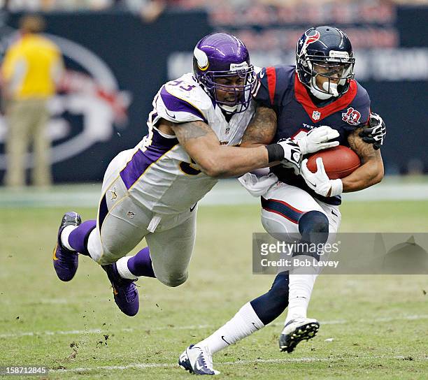 DeVier Posey of the Houston Texans is tackled from behind by Kevin Williams of the Minnesota Vikings at Reliant Stadium on December 23, 2012 in...