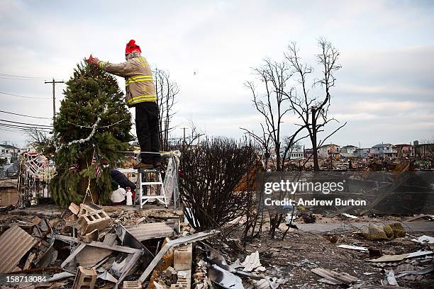 Edward "Roaddawg" Manley, a volunteer and honory firefighter with the Point Breeze Volunteer Fire Department, places a star on top of a Christmas...