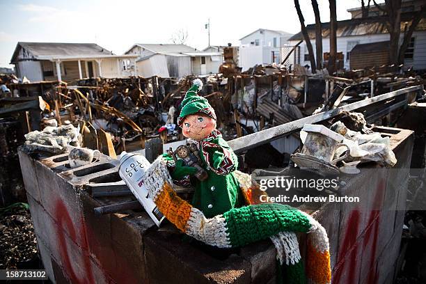 Holiday doll rests amongst the remains of burned houses in the Breezy Point neighborhood of the Borough of Queens on December 25, 2012 in New York...