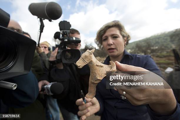 Israel Antiquities Authority archeologist Anna Ririkh displays on December 26, 2012 a clay figurine used for religious rituals and practices, dated...