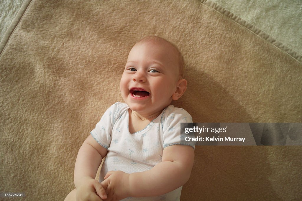 Baby laughing on rug