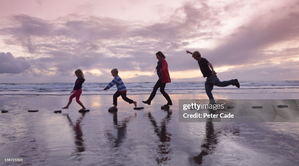 Family walking over stepping stones on beach