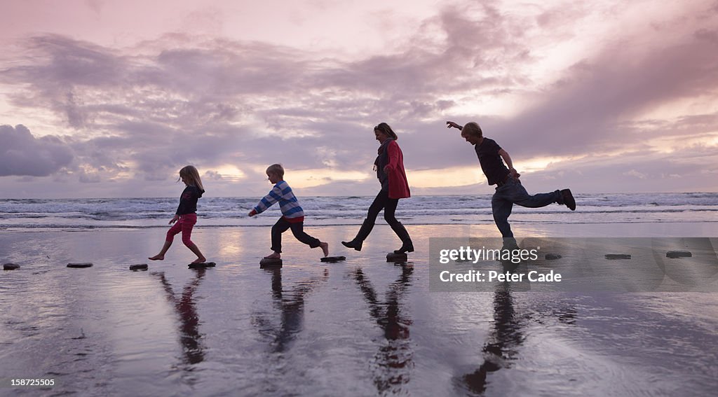 Family walking over stepping stones on beach