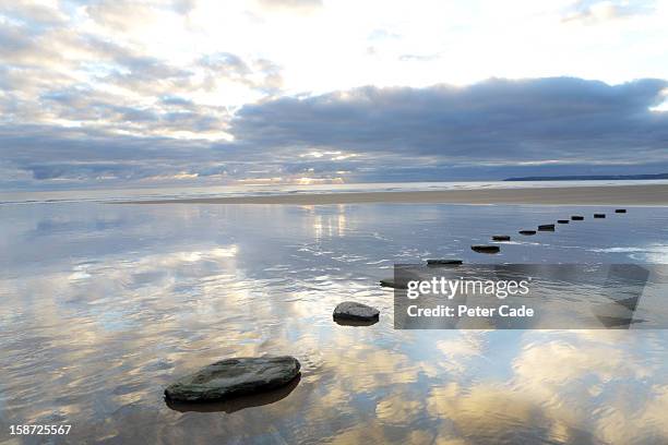 stepping stones over water with sky reflections - stepping stone stock-fotos und bilder