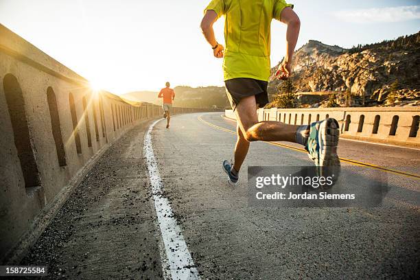 two men on an early morning run. - physically active stock pictures, royalty-free photos & images