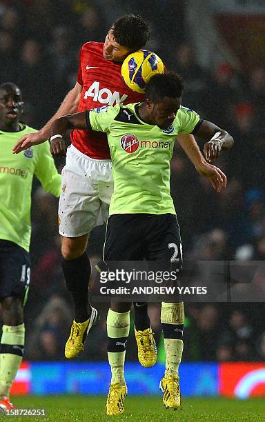 Manchester United's English midfielder Michael Carrick jumps to win a header against Newcastle United's Burundi midfielder Gael Bigirimana during the...