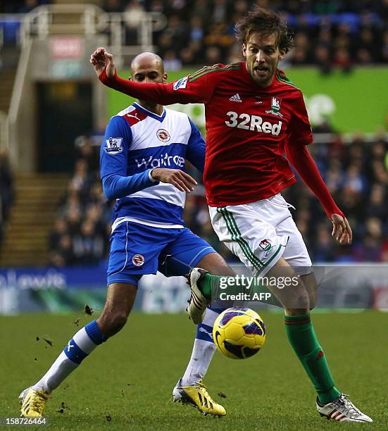 Swansea city's Spanish midfielder Miguel Michu vies for the ball against Reading's Malian midfielder Jimmy Kebe during the English Premier League...