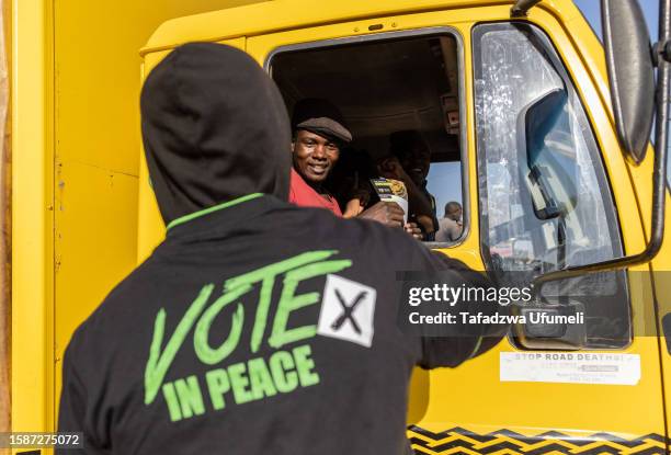 Members of the public receive pamphlets during Zimbabwe's 2023 general election voter education campaign by a local civil society organisation on...