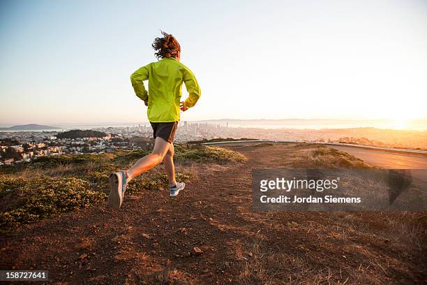a fit man running during sunrise. - twin peaks stock pictures, royalty-free photos & images