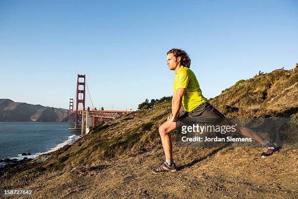 a man running during sunset. - baker beach stock pictures, royalty-free photos & images