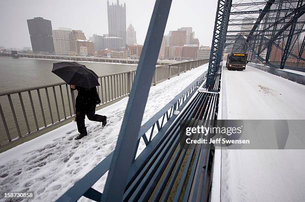 Pedestrian crosses the Smithfiled Street Bridge after a winter storm blanketed the Midwest with snow December 26, 2012 in Pittsburgh, Pennsylvania....