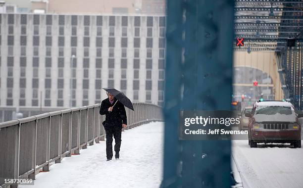 Pedestrian crosses the Smithfiled Street Bridge after a winter storm blanketed the Midwest with snow December 26, 2012 in Pittsburgh, Pennsylvania....