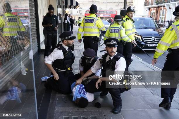 Police officers detain a man near Oxford Street in central London. Picture date: Wednesday August 9, 2023.