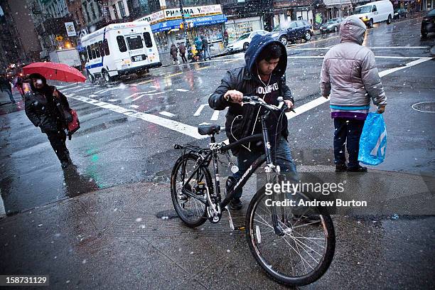 Cyclist pushes his bike through a winter snowstorm on December 26, 2012 in New York City. Snow, mixed with and changing to rain, is expected to hit...
