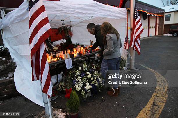 Mourners place an American flag at a a makeshift memorial at the West Webster Fire Station on Wednesday, December 26, 2012 in Webster, New York. Law...