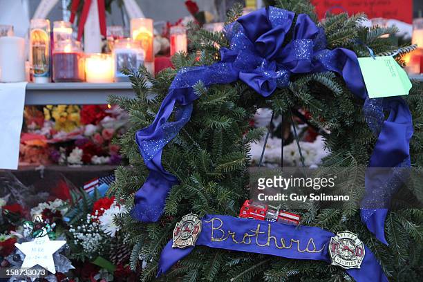 Flowers, candles and wreaths adorn a makeshift Memorial at the West Webster Fire Station on Wednesday, December 26, 2012 in Webster, New York. Law...