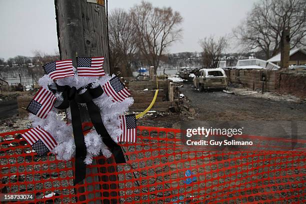 Wreath with American flags hangs on a pole at the site of the Christmas eve shooting and fires on Wednesday, December 26, 2012 in Webster, New York....
