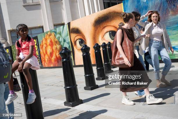 The eyes from a detail of Antonello da Messina's 'Portrait of a Man' look to passers-by as they walk past the National gallery in Trafalgar Square...