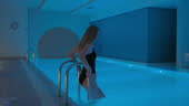 Young Woman Diving Into The Pool Young Woman Entering The Indoor Pool ...
