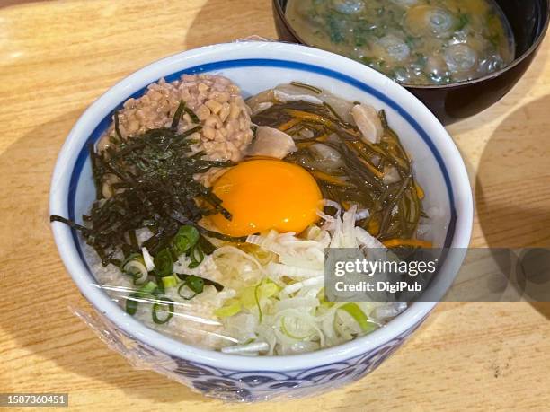 neba neba don, sticky and slimy rice bowl, rice with natto (fermented soybean), mekabu (root of the wakame seaweed) and raw egg yolk toppings, covered with stretch film as a food sample shown during lunchtime at a washoku restaurant - natto stock pictures, royalty-free photos & images