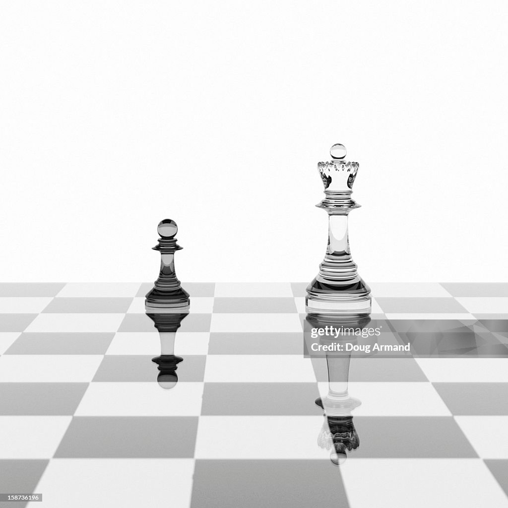 Pawn and queen chess pieces on a glossy board