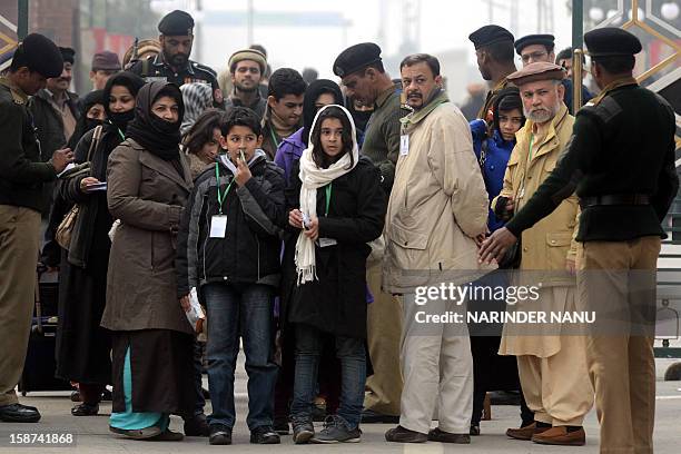 Pakistani Ahmadiyya Muslims wait as their documents are checked by officials at The India-Pakistan Wagah Border Post on December 27, 2012. Thousands...