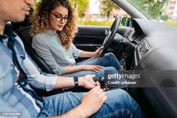 jeune femme prenant une leçon de conduite avec un instructeur de conduite - levier de vitesse photos et images de collection