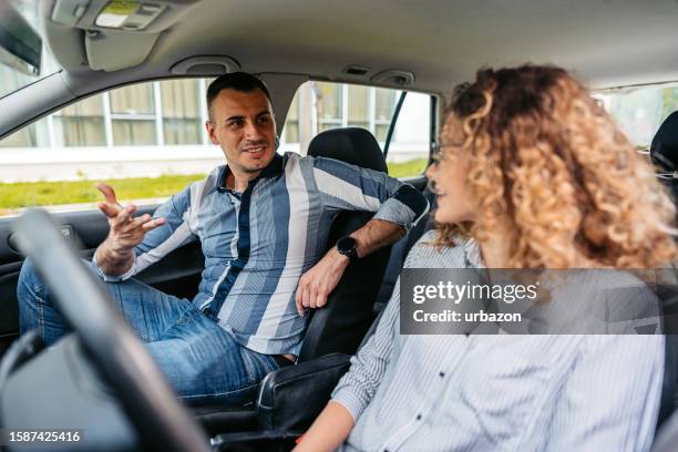 junge frau hat eine fahrstunde mit einem männlichen fahrlehrer - front passenger seat stock-fotos und bilder