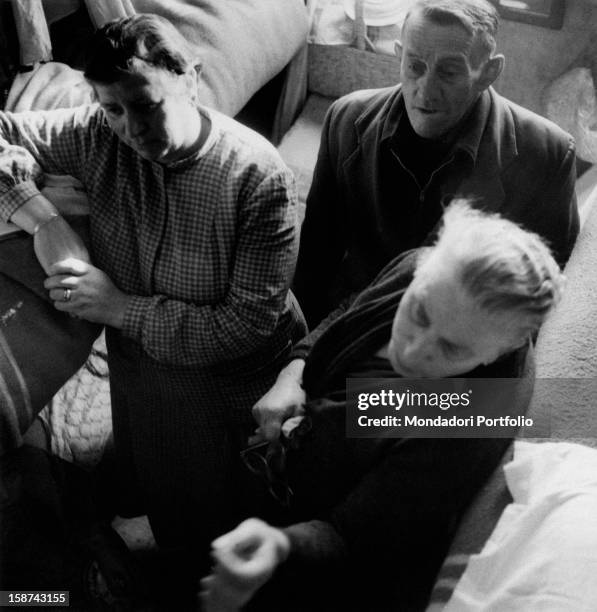 Istrian refugees standing in a bedroom. Trieste, 14th January 1956