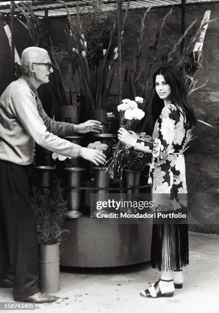 The Italian singer and actress Rosanna Fratello buying a bunch of flowers. Milan, 1972