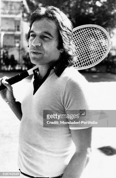 Fred Bongusto, born Alfredo Antonio Carlo Buongusto, a popular pop-music singer, holds a racket on his shoulder in a tennis court. Rome, Italy, 1975.