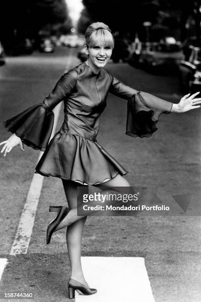 Italian actress and singer Carmen Villani crossing the road on a pedestrian crossing. Milan, 1970s