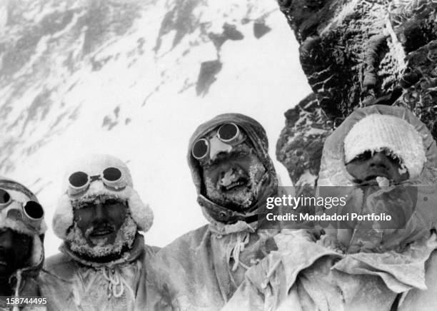 Four members of the expedition for the conquest of K2, covered in their anoraks, smile to the photographs; from right, they're Sergio Viotto, Lino...