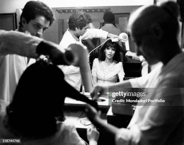 Ombretta Colli is having her hair fixed by the hairstylists in the dressing room in front of the mirror before recording Giandomenico Fracchia -...