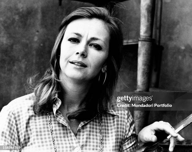 Italian actress Lorella De Luca smoking a cigarette beside an iron staircase. Rome, 1974