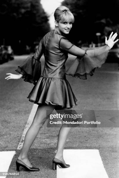 Italian actress and singer Carmen Villani crossing the road on a pedestrian crossing. Milan, 1970s