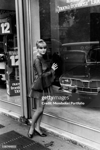 Italian actress and singer Carmen Villani looking at a shop window. Milan, 1970s
