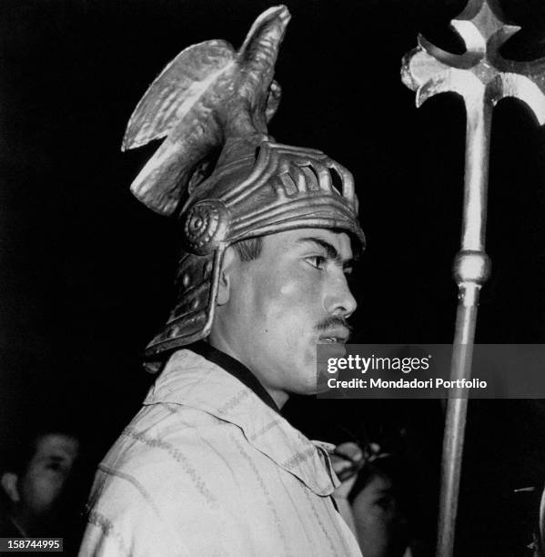 Man wearing a traditional headdress during a historical reenactment. 1960s