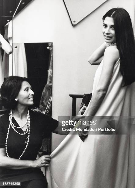 The costume designer Pia Rame tidyng up the dress of the Italian singer and actress Rosanna Fratello . Milan, 1970