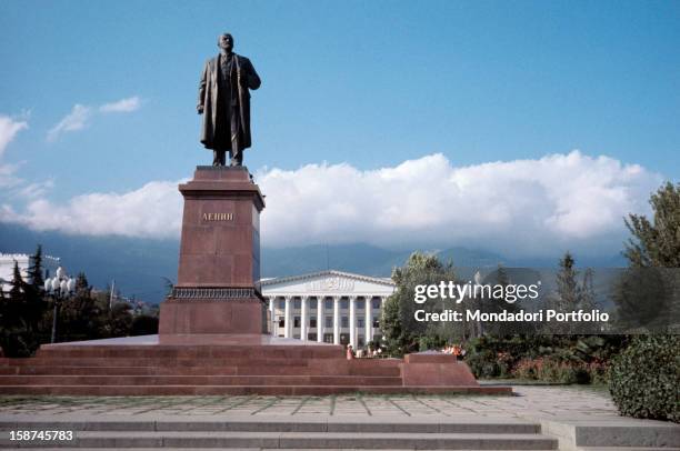 Sight of the monument to Lenin, from the bottom upwards, with the neoclassic municipal palace and the mountains' profile on the background. Yalta ,...