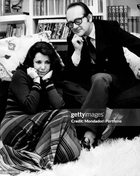 Italian director and writer Pasquale Festa Campanile sitting in the livingroom with Italian actress Grazia Maria Spina . Rome, 1970s