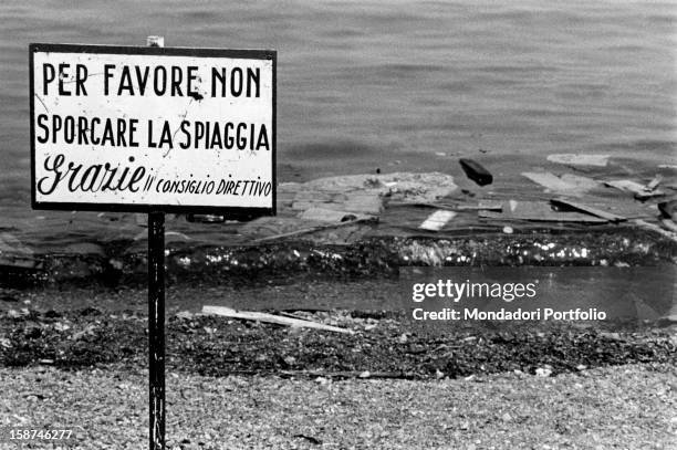 Waste and garbage abandoned on the Arenzano beach beside a sign saying "Do not soil the beach". Arenzano, August 1972