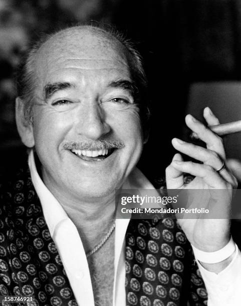 French record-company owner Eddie Barclay smoking a cigar and smiling. Paris, 1970s