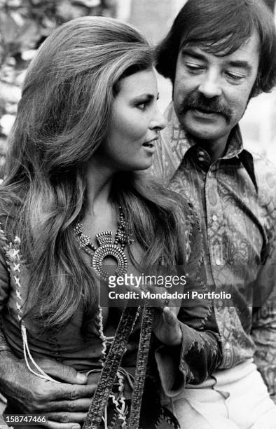 American actor Richard Johnson seizing American actress Raquel Welch by the waist. Rome, 1970s