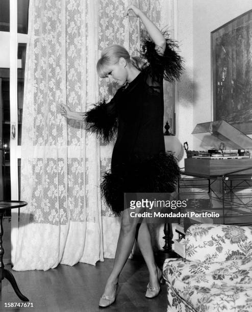Italian actress and singer Carmen Villani dancing in her house. Milan, October 1968