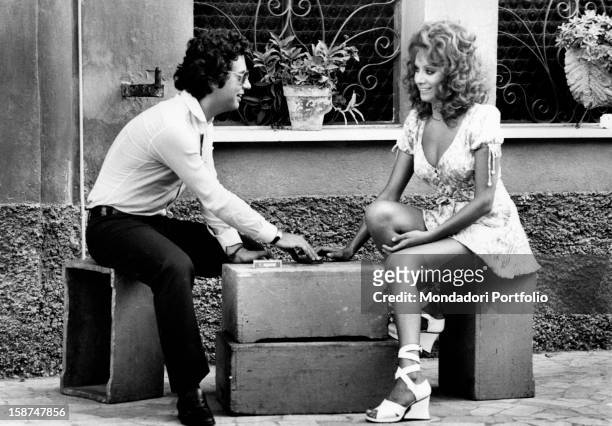 Italian actress and singer Maria Grazia Buccella sitting and talking with her fiancée, the film producer Vittorio Cecchi Gori. Rome, 1970s