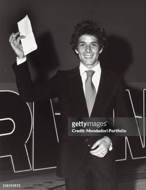Italian actor Gabriele Lavia holding a piece of paper and posing. Taormina, 1973